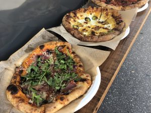 Additional shot of all 3 pizzas on the bar