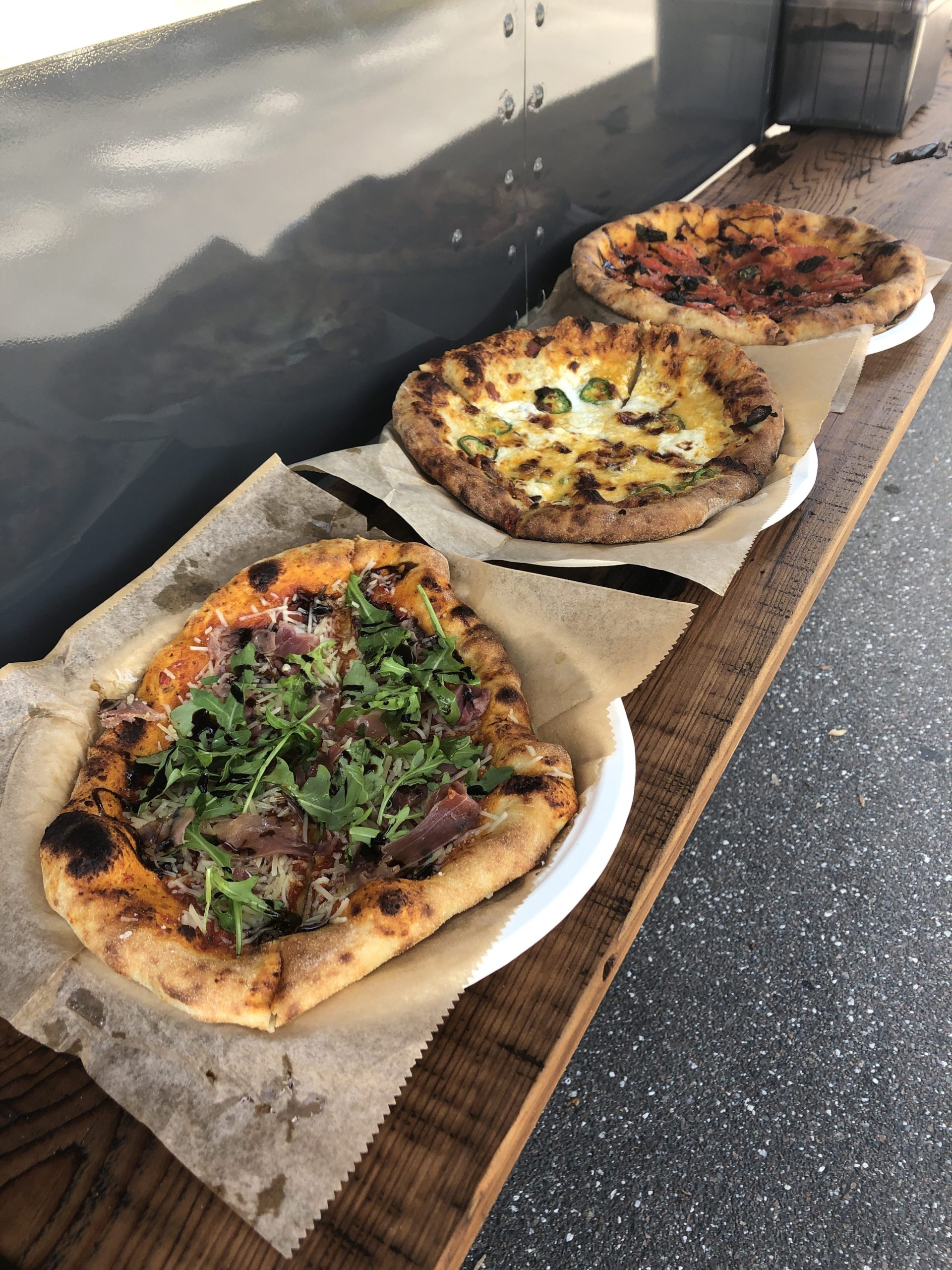 Additional shot of all 3 pizzas on the bar