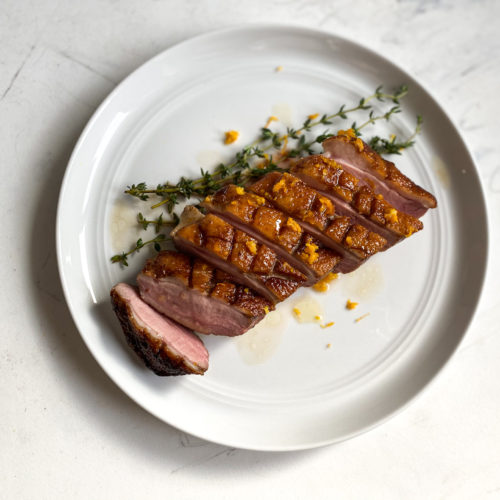 Sliced sous vide duck breast with orange sauce