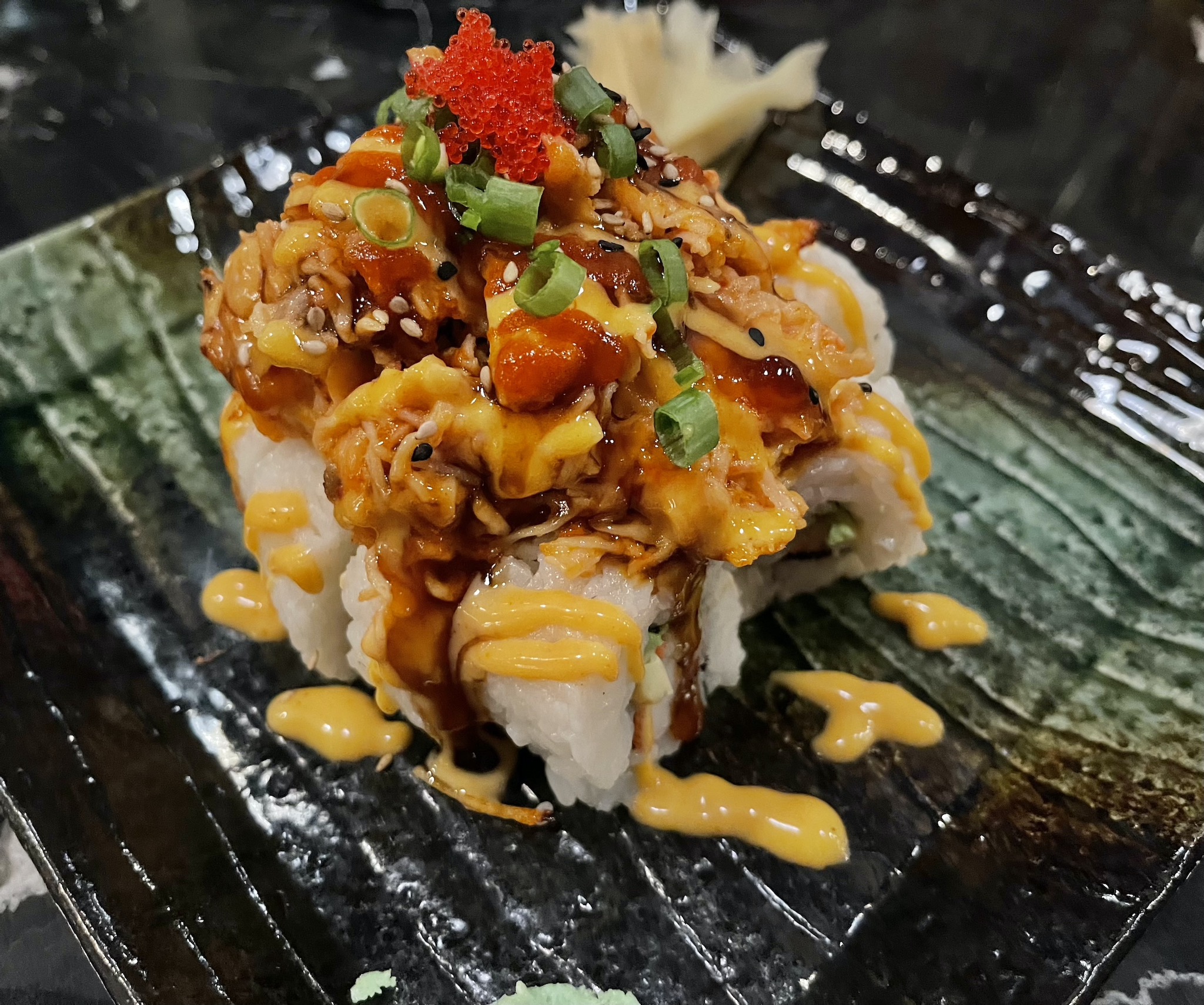 https://stpetersburgfoodies.com/wp-content/uploads/2022/03/Volcano-Roll-California-roll-baked-spicy-salmon-sesame-seeds-masago-shrimp-sauce-teriyaki.jpeg