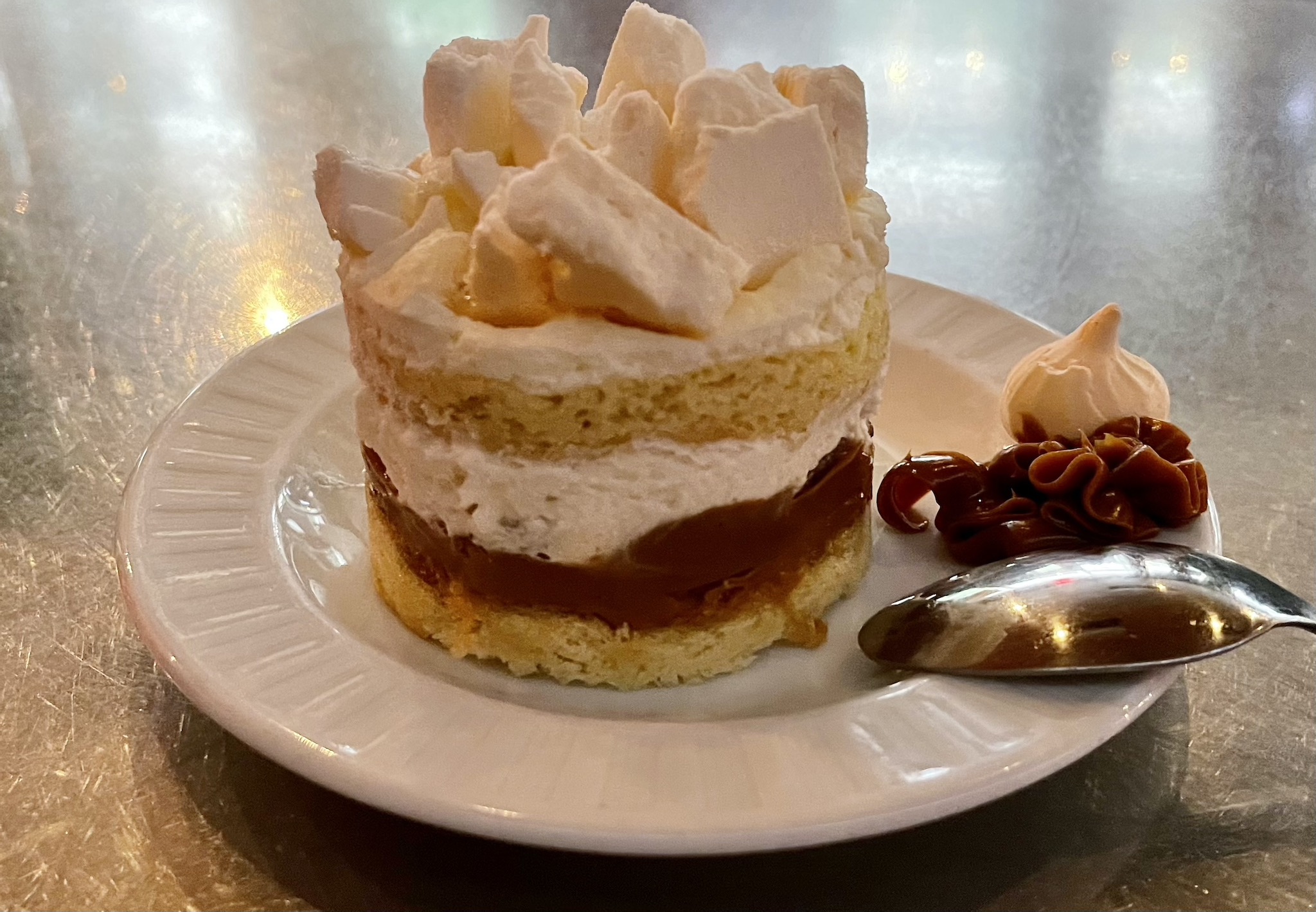 Renzo's Chaja - Renzo's signature dessert. Home-made sponge cake, layered with dulce de leche caramel, peaches and walnuts. Covered in chantilly and topped with meringue crumbles