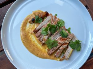 Pork chops with charred jalapeño and peach puree plated