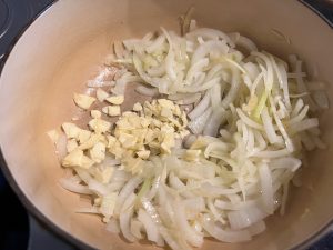 Adding the garlic to the onions