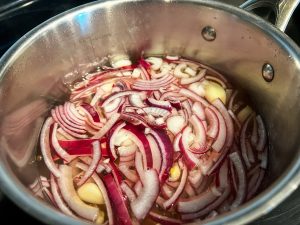 Adding in the onions to the picling mixture