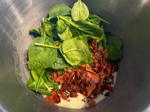 Cheese, bacon and spinach added to the egg mixture