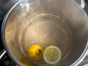 Heating the water, lemon and salt to poach the shrimp