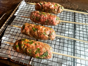 Kofta formed on the wooden skewers before their bake in the oven