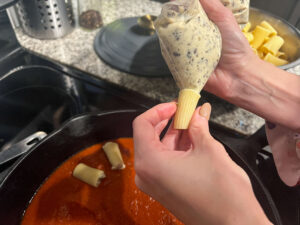 Piping the filling into the rigatoni